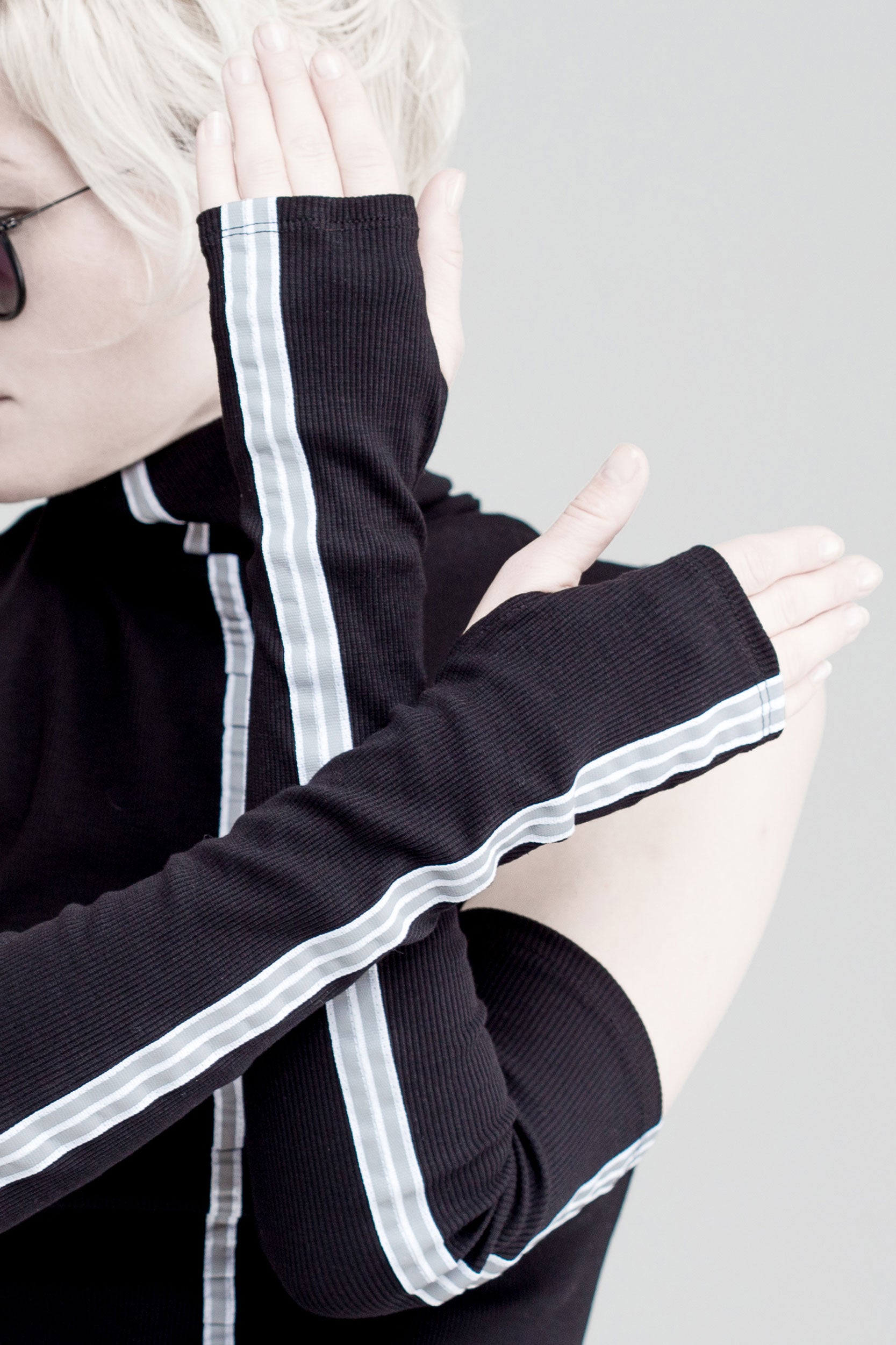 Black sleeveless turtleneck top with long fingerless gloves